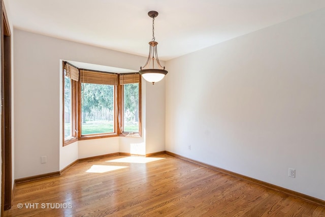 empty room featuring light wood-type flooring and baseboards