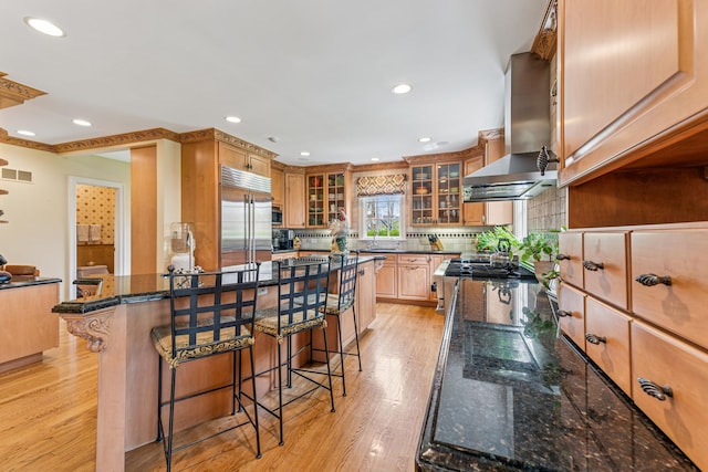 1135 Buttonwood Ln, Northbrook, IL 60062 - kitchen featuring a sink, a breakfast bar, ventilation hood, decorative backsplash, and appliances with stainless steel finishes