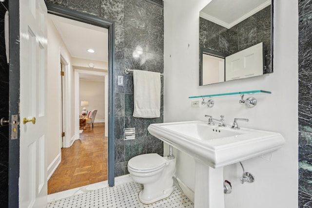 bathroom featuring toilet, tile walls, and crown molding