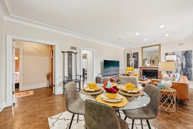 dining room with a fireplace, visible vents, baseboards, ornamental molding, and recessed lighting