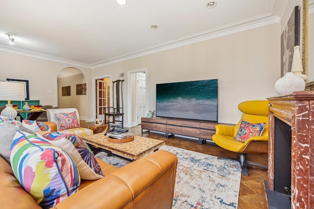 living room with crown molding, a fireplace, arched walkways, and recessed lighting