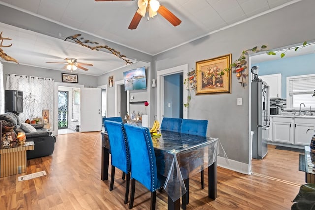 135 N Calhoun St, Aurora, IL 60505 - dining space featuring a ceiling fan, crown molding, light wood-type flooring, and baseboards