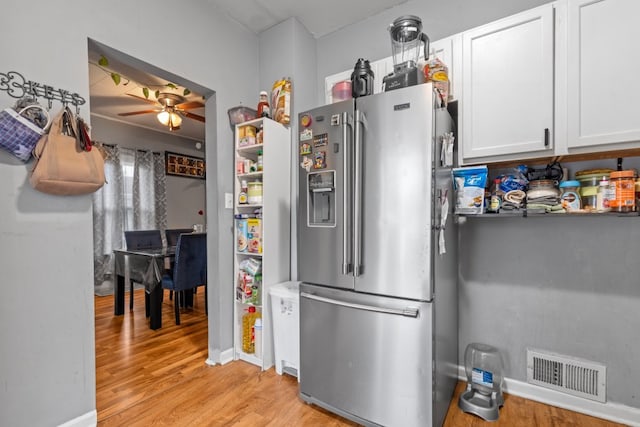 135 N Calhoun St, Aurora, IL 60505 - kitchen featuring stainless steel fridge, light wood-type flooring, a ceiling fan, white cabinets, and baseboards