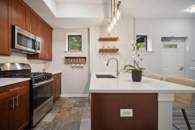 kitchen with a breakfast bar area, backsplash, a sink, light countertops, and stainless steel appliances