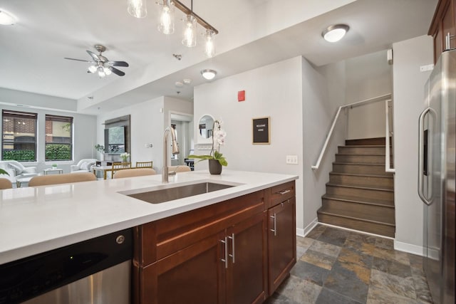 kitchen with baseboards, ceiling fan, light countertops, a sink, and appliances with stainless steel finishes