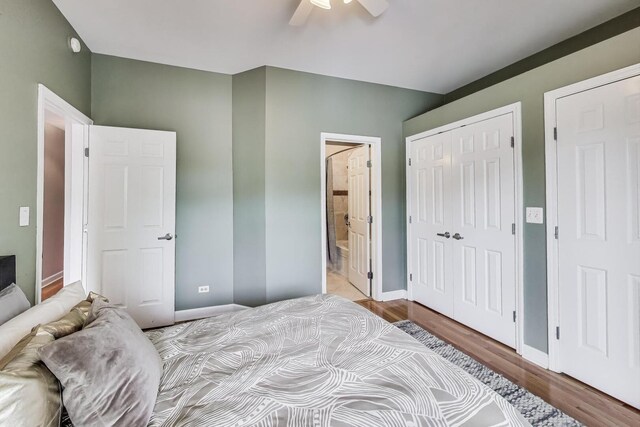 bedroom with a ceiling fan, wood finished floors, baseboards, a closet, and ensuite bathroom