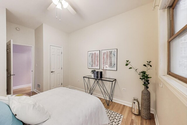 bedroom featuring a ceiling fan, baseboards, and light wood-type flooring