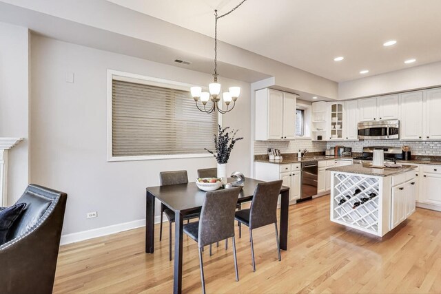 dining area with visible vents, baseboards, light wood-type flooring, recessed lighting, and a chandelier