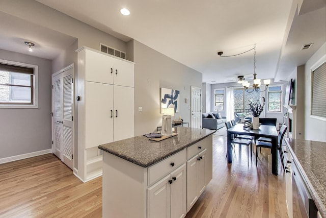 kitchen with visible vents, light wood finished floors, a healthy amount of sunlight, and white cabinetry