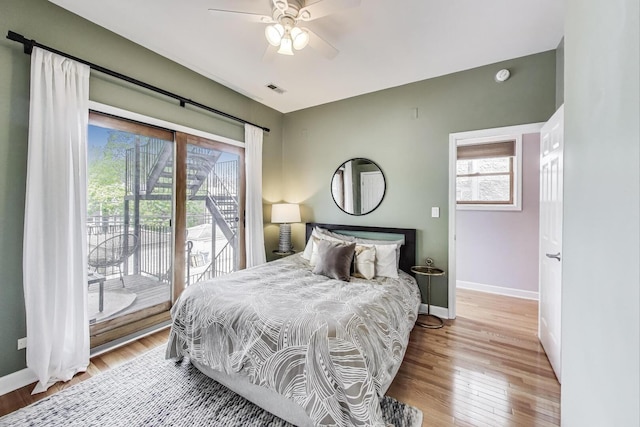 bedroom with access to outside, baseboards, visible vents, and wood finished floors