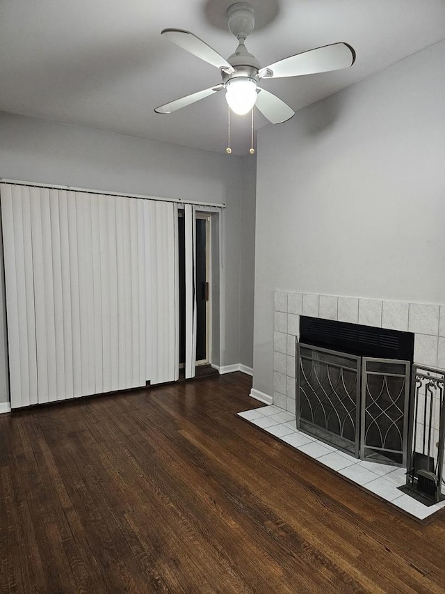 unfurnished living room featuring baseboards, wood finished floors, a fireplace, and ceiling fan