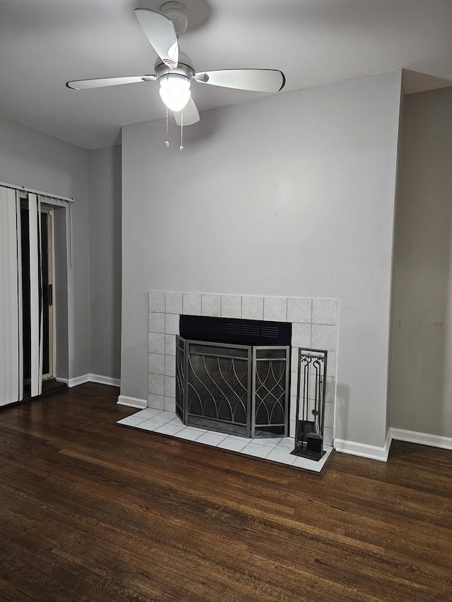 room details with a tile fireplace, ceiling fan, baseboards, and wood finished floors