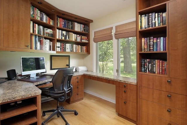 office space with light wood-type flooring and built in desk