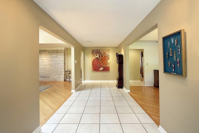 hallway with light wood-type flooring and baseboards