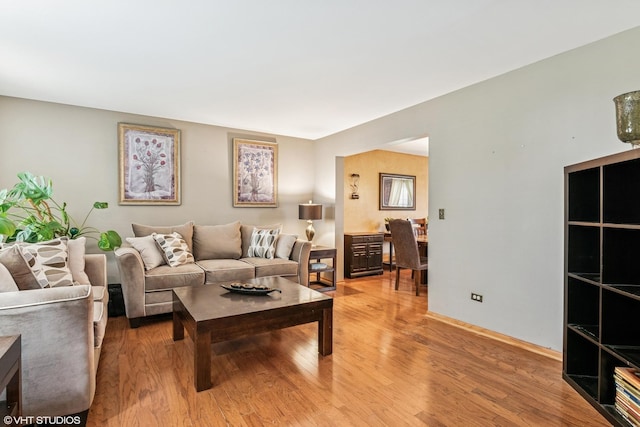 living area with light wood-type flooring and baseboards
