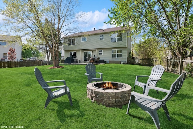 back of house with a lawn, a fenced backyard, and a fire pit