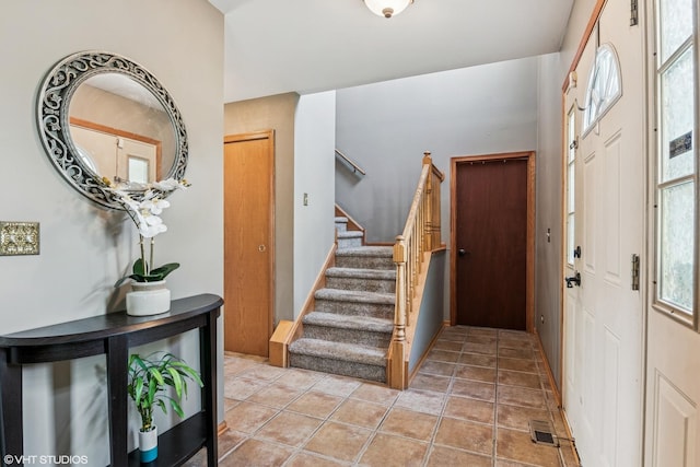 foyer entrance featuring visible vents and stairs