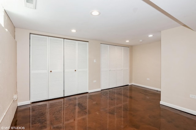 unfurnished bedroom with recessed lighting, baseboards, and two closets