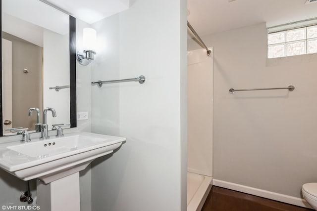 full bathroom featuring a shower, toilet, and a sink