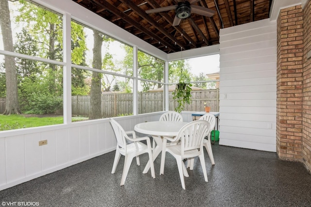 sunroom featuring a ceiling fan and outdoor dining area