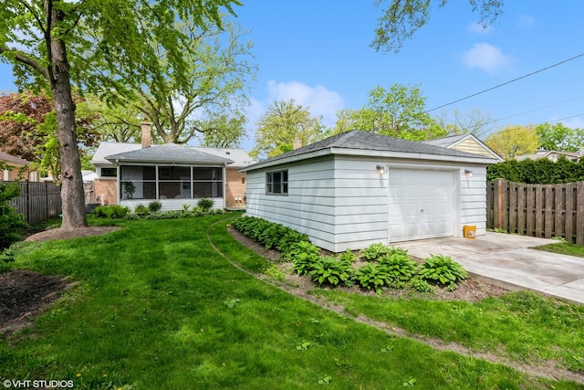 rear view of property with concrete driveway, an outdoor structure, a sunroom, a chimney, and a garage