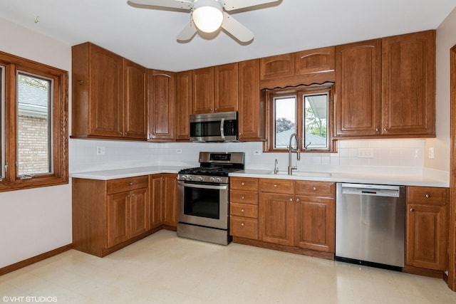kitchen featuring stainless steel appliances, a sink, healthy amount of natural light, and backsplash