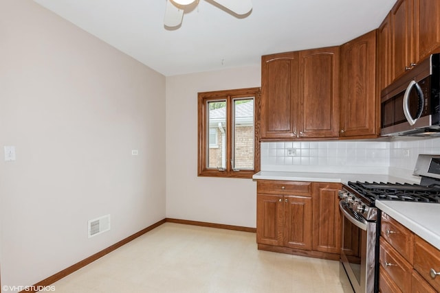 kitchen with appliances with stainless steel finishes, light countertops, decorative backsplash, ceiling fan, and baseboards
