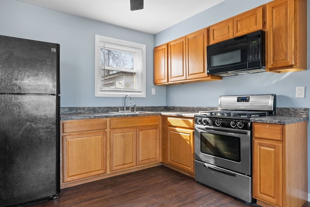 kitchen featuring dark wood-style floors, a sink, dark countertops, brown cabinetry, and black appliances
