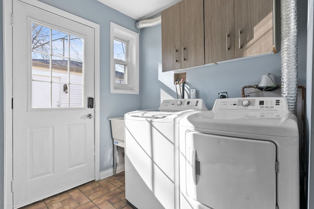 laundry room featuring cabinet space, baseboards, brick patterned floor, and separate washer and dryer