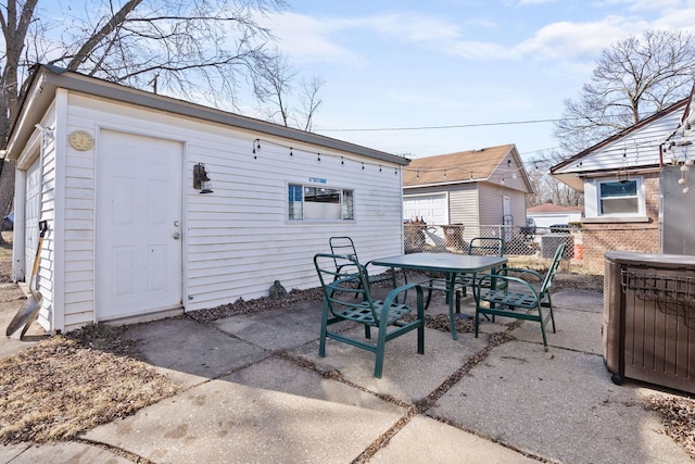 exterior space featuring outdoor dining area, fence, and an outbuilding