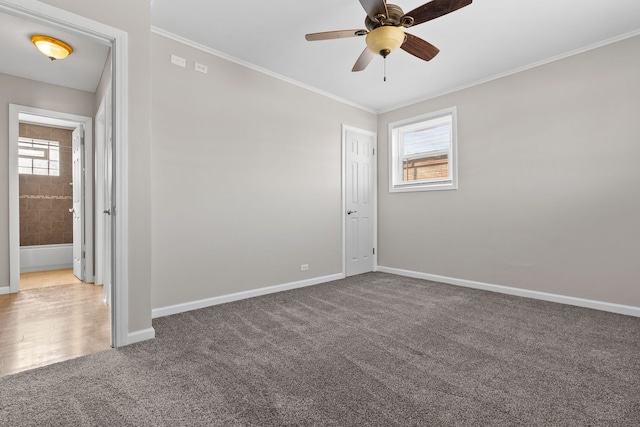 empty room featuring a wealth of natural light, a ceiling fan, carpet flooring, and baseboards