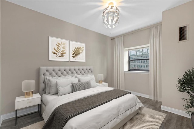 bedroom with a notable chandelier, baseboards, dark wood-style flooring, and visible vents