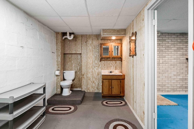 bathroom with a paneled ceiling, vanity, and toilet