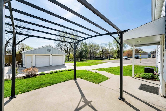 view of patio featuring a detached garage and an outbuilding