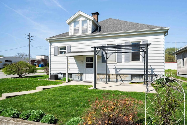 view of front of property featuring a chimney, a pergola, a front lawn, a patio, and roof with shingles