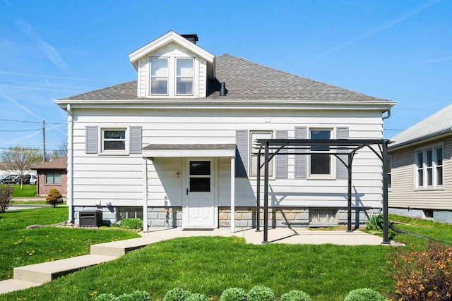 view of front of home with cooling unit, a shingled roof, and a front lawn
