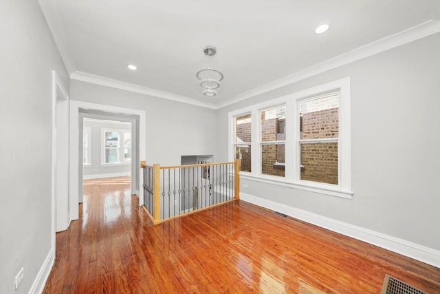 8045 S Escanaba Ave, Chicago, IL 60617 - empty room featuring visible vents, baseboards, wood finished floors, and crown molding