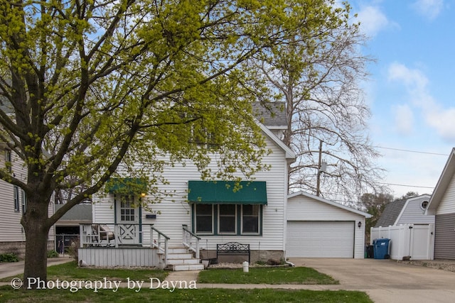 view of front of home with a detached garage and fence