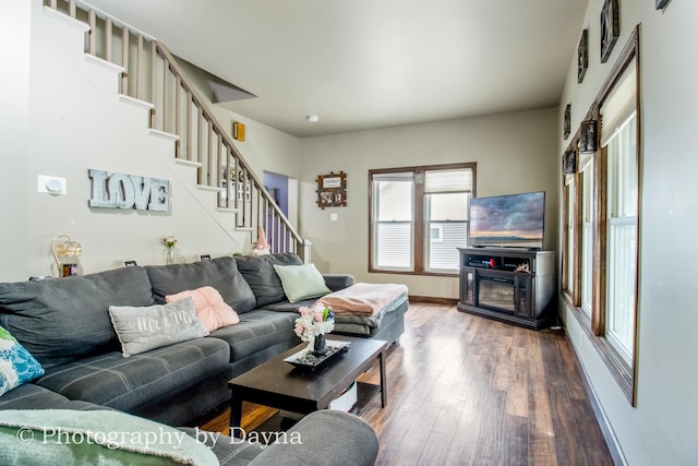 living area with baseboards, wood finished floors, and stairs