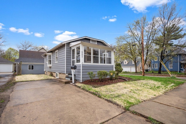 bungalow-style house featuring a front lawn and a sunroom