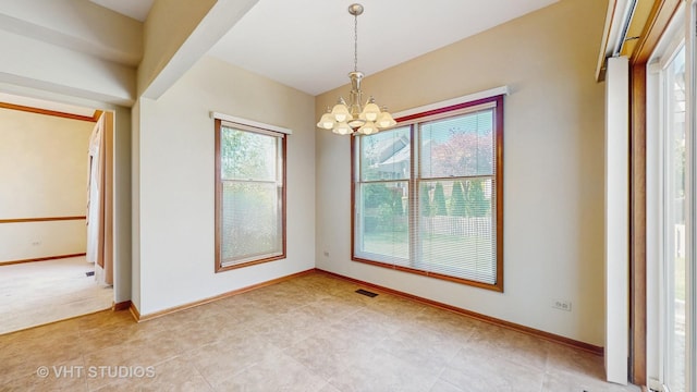 unfurnished dining area featuring a chandelier and baseboards