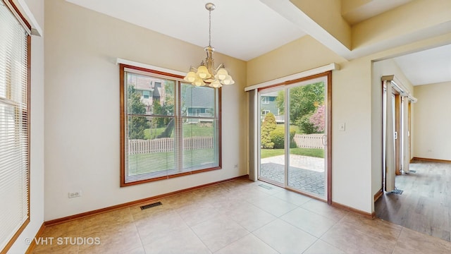 unfurnished dining area with a chandelier, baseboards, and light tile patterned floors