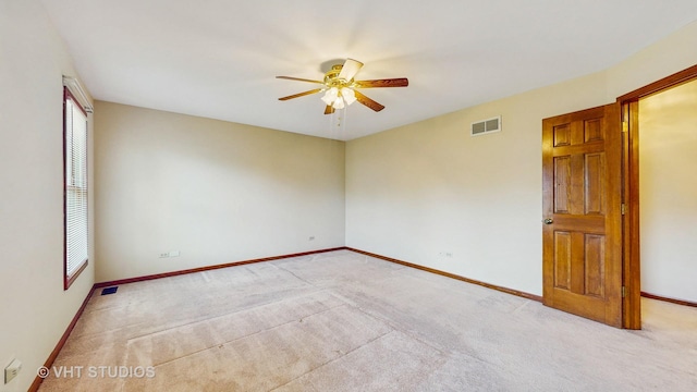 empty room featuring a ceiling fan, baseboards, and light carpet