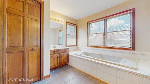 bathroom with tile patterned floors, a bath, and vanity