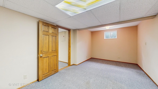below grade area featuring carpet flooring, a paneled ceiling, and baseboards