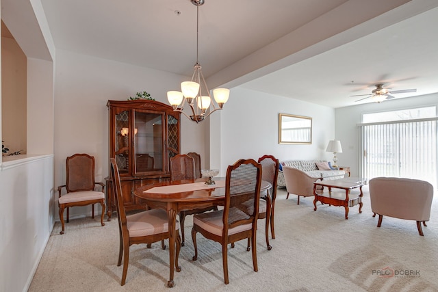 dining room with light carpet and ceiling fan with notable chandelier