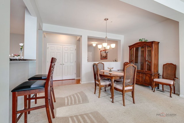 dining space with an inviting chandelier, baseboards, and light carpet