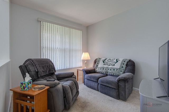 carpeted living area featuring baseboards