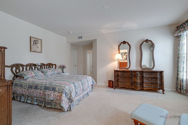 carpeted bedroom featuring baseboards and visible vents