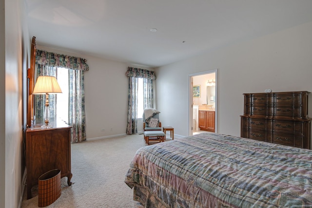 bedroom with baseboards, carpet, and ensuite bath